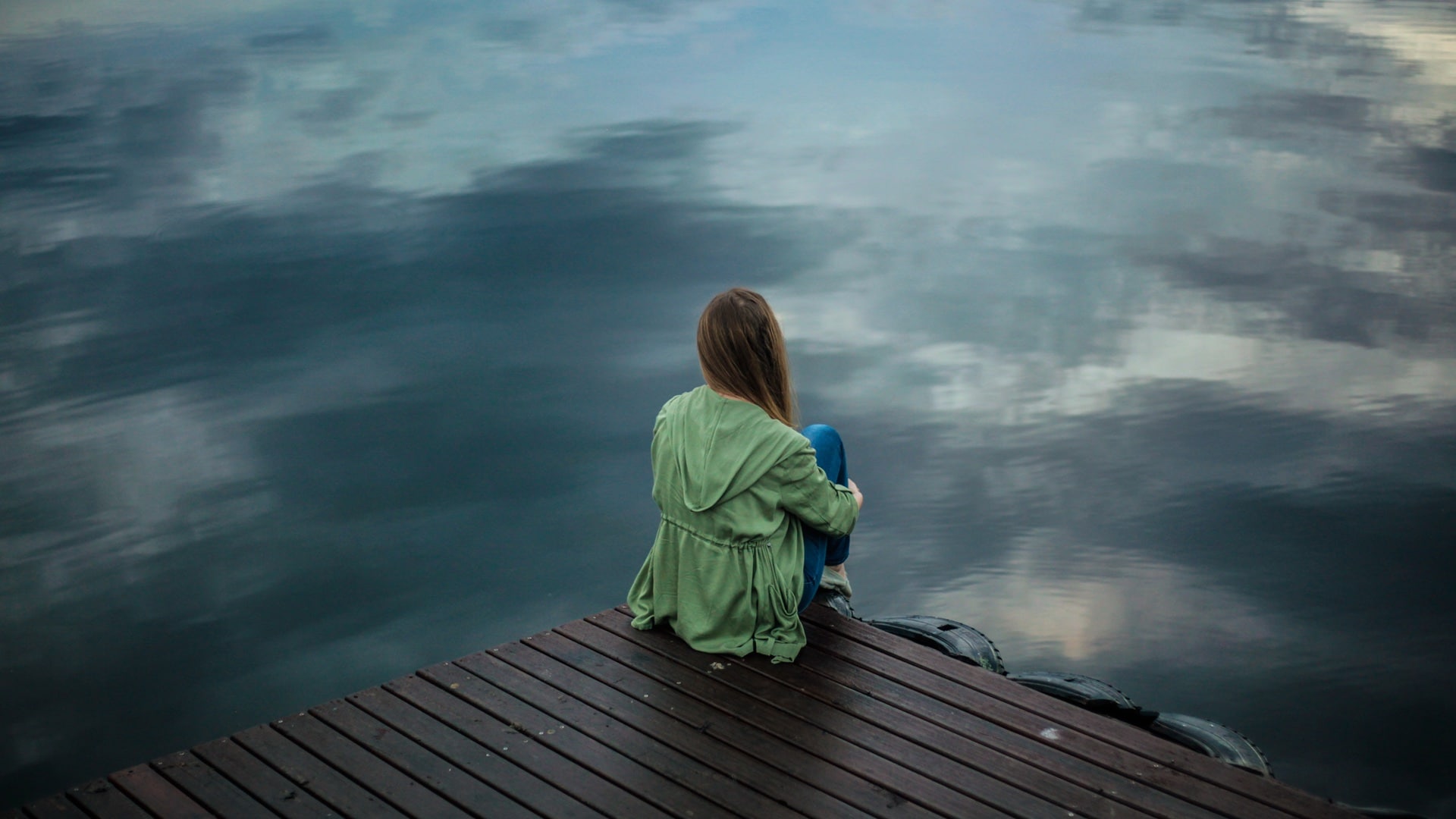 solitude woman sitting on dock lake