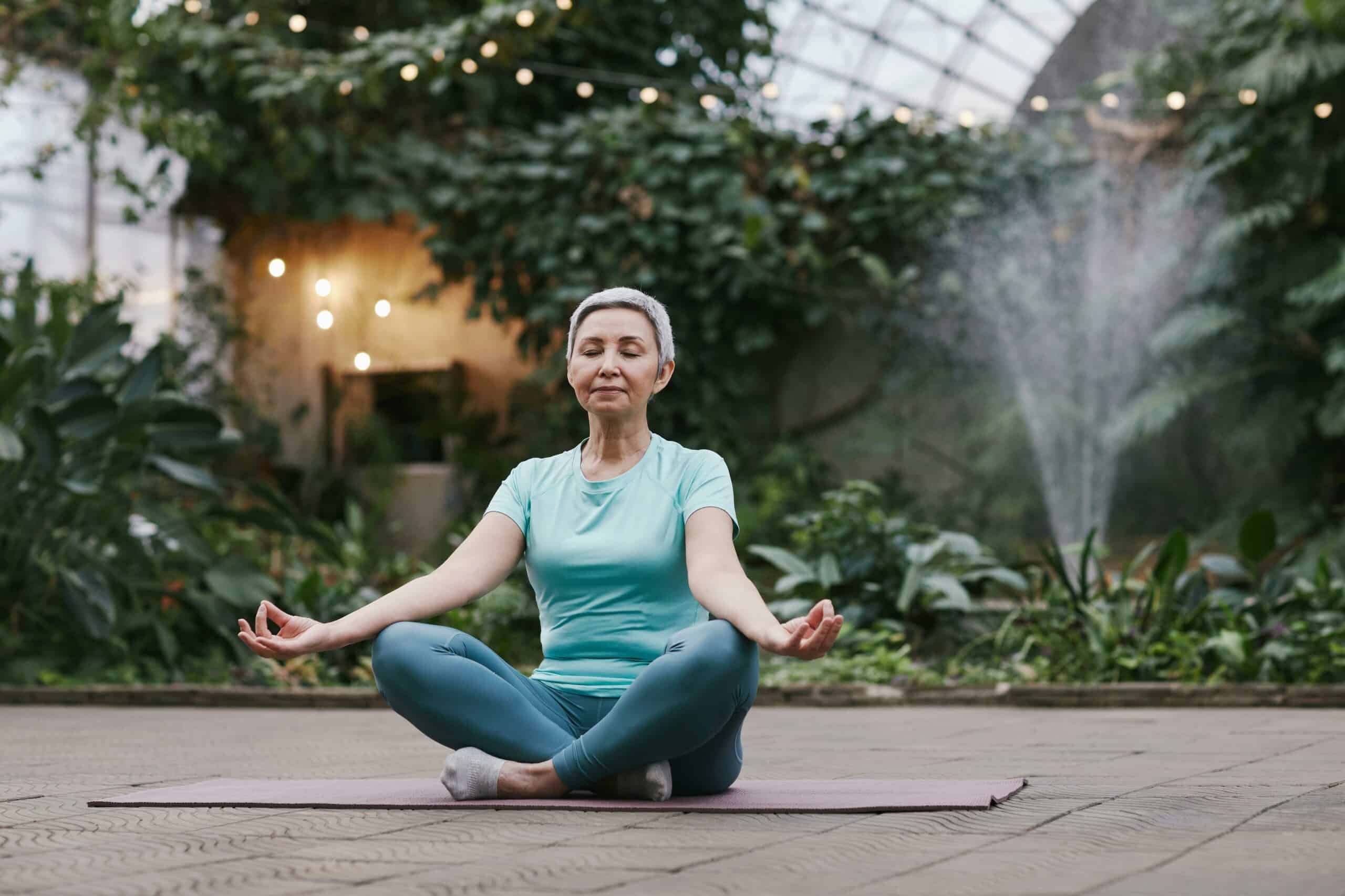 woman meditating peacefully in a serene greenhouse setting