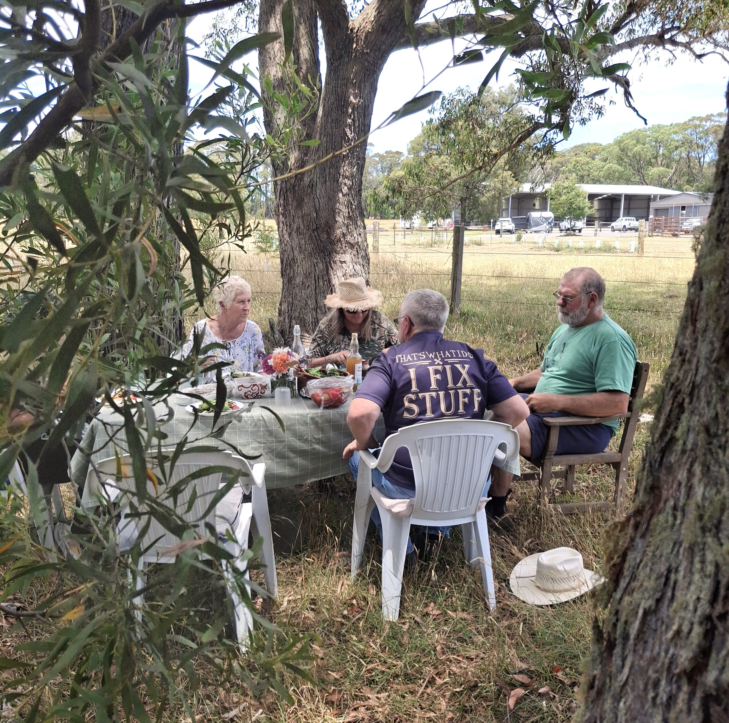 people sitting around table in forest eating 