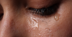 Close-up of a tearful eye with mascara smudge.