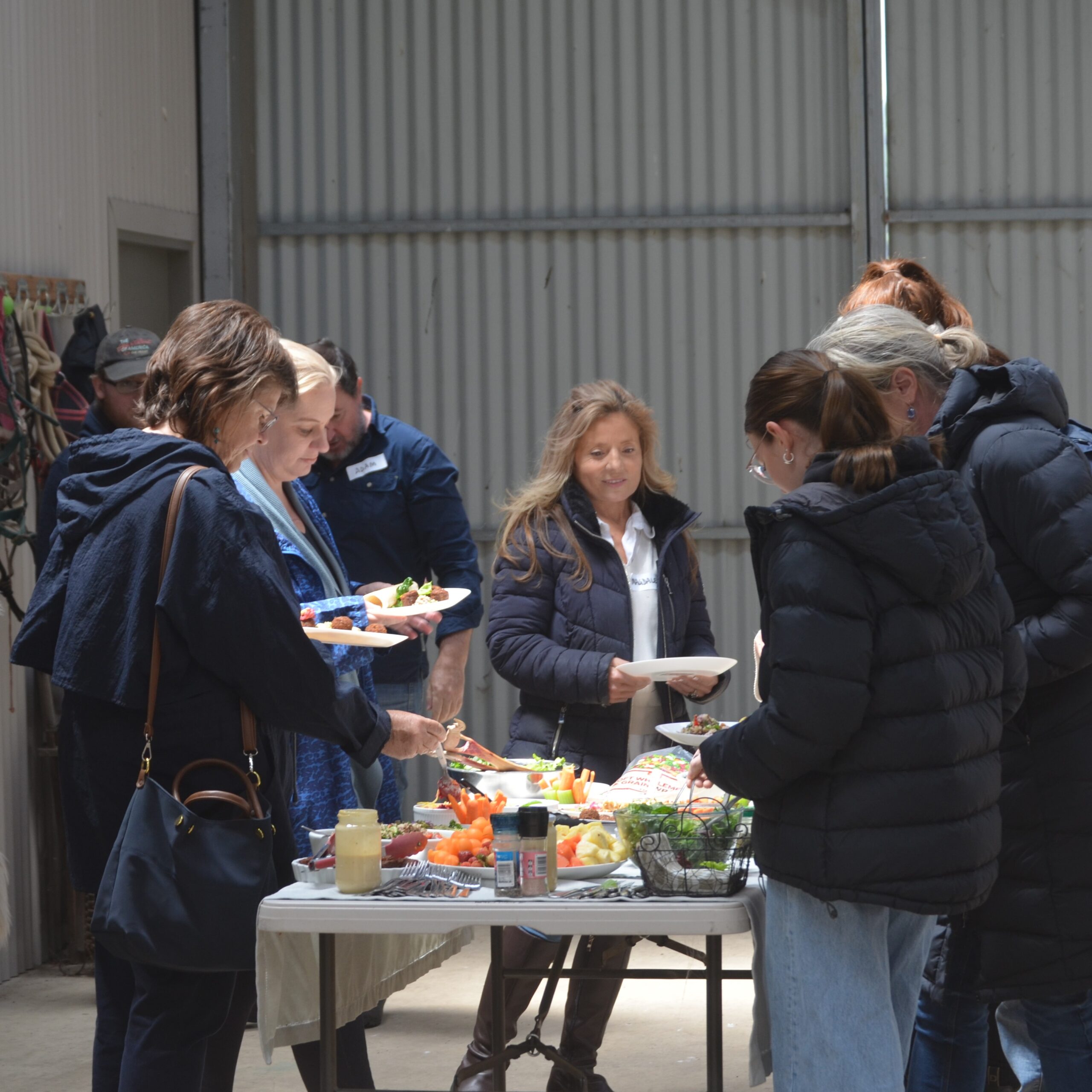 People enjoying buffet table at indoor gathering.